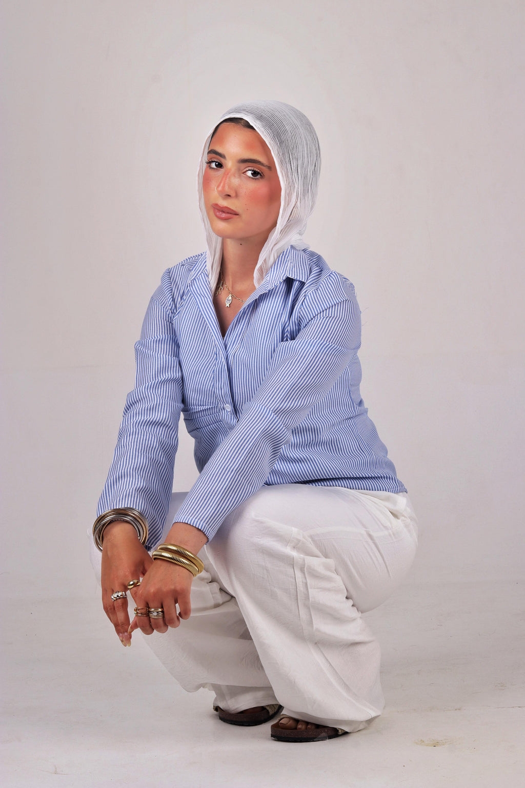 a blue striped shirt and white headscarf