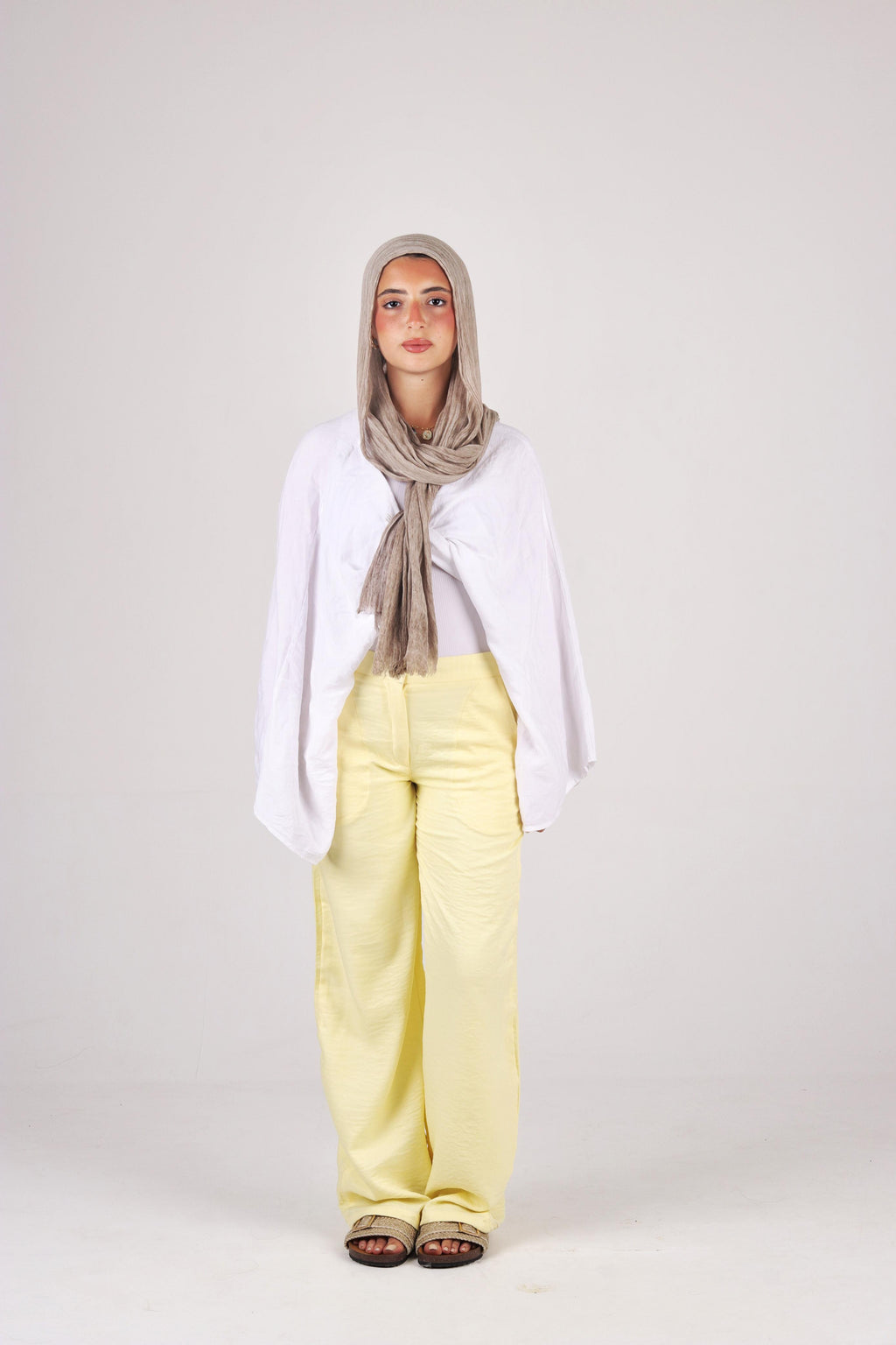 a white top, yellow pants, and a gray hijab on a white background