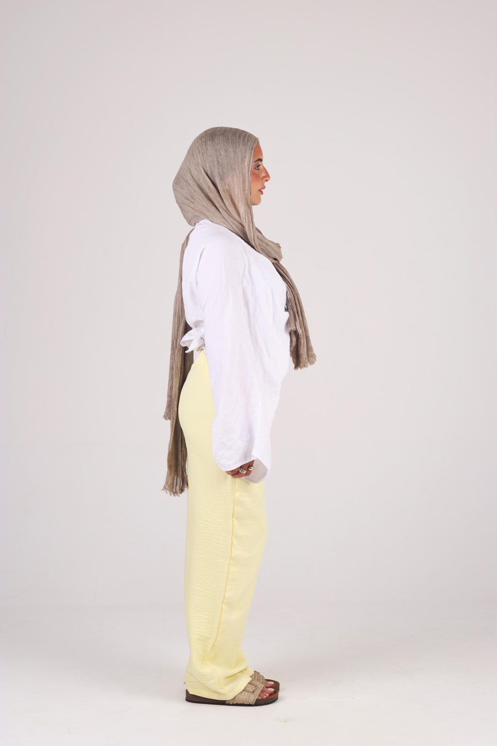 a white shirt, yellow pants, and a brown hijab on a white background